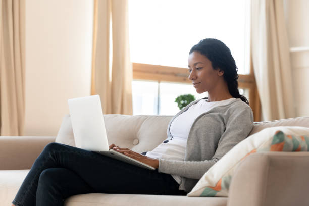 istock African American woman relax on sofa using laptop 1210820281