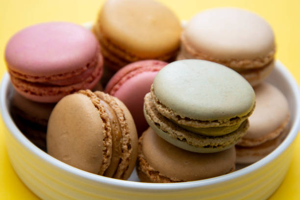 istock Colorful macaroons cookies dessert on a plate, with yellow background. 1210820306