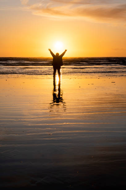 istock mature woman on beach at sunset 1210820775