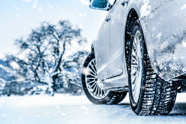 Winter tire. Car in winter. Tires on snowy road detail stock photo