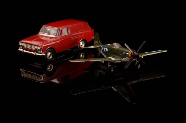 istock Die cast model car and model plane on the black reflective surface 1210821646