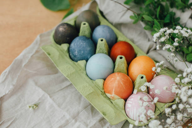 istock Modern yellow, pink, blue and grey easter eggs painted with organic onion, beets, red cabbage, carcade tea. Zero waste holiday. Natural dye easter eggs in carton tray on rustic table with flowers 1210822002