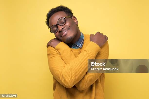 Revolutionerende Spiller skak Atlas African American Man In Yellow Clothes And Glasses Hugs Himself Stock Photo  - Download Image Now - iStock