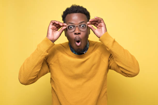 istock man looks into camera, rounds lips with surprisment, stares through spectacles 1210823070