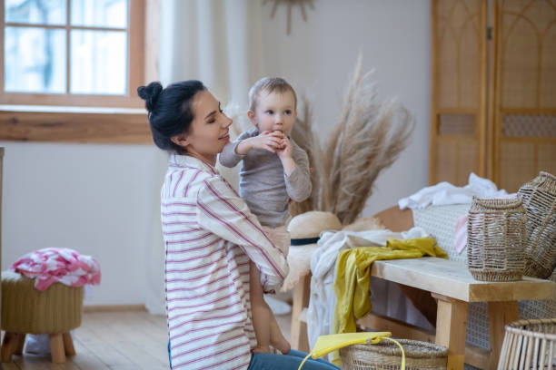 istock Young mom holding her daugher, girl eating bread roll 1210824577