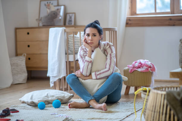 istock Sad young woman hugging pillow, propping up her head 1210824580