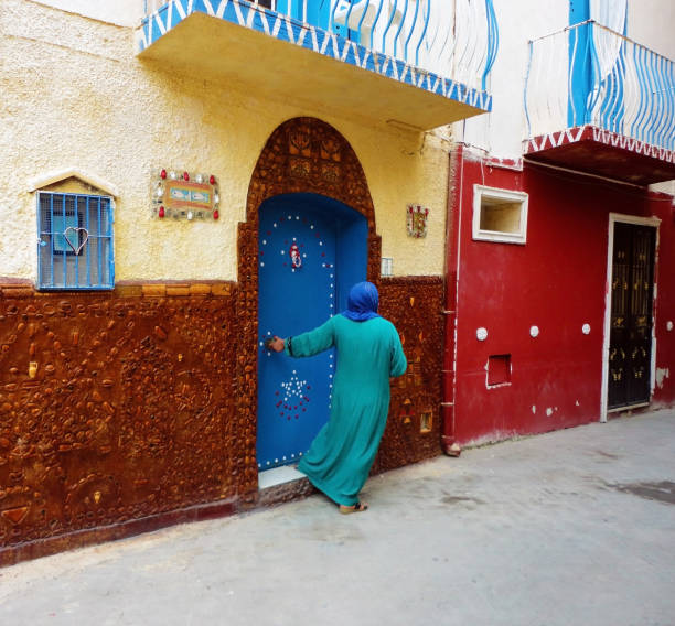 Muslim woman comes out the door of her house in the Arab quarter of the historic center, 20 Sep 2019 Mazara del Vallo Sicily