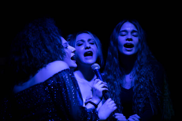 istock Four young girls performing karaoke 1210824707
