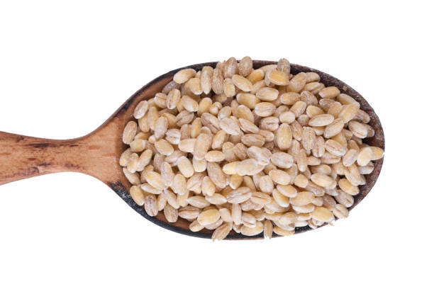istock Wooden spoon with pearl barley isolated on a white background. 1210825746