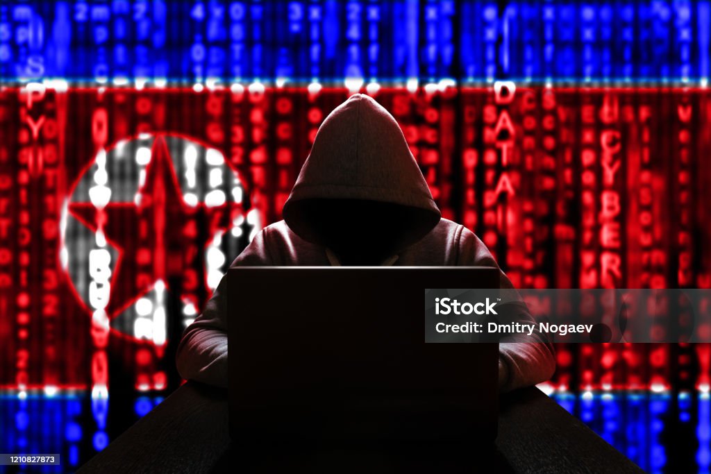 Cyber threat from North Korea. North Korean hacker at the computer, on a background of binary code, the colors of the flag of the DPRK. DDoS attack North Korea Stock Photo