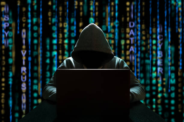 istock Cyber threat of an unknown hacker sitting in front of a computer against a background of binary code. Cyber security 1210827902