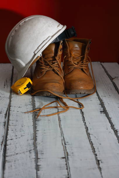 istock Work boots, with white architect's helmet and metric tape 1210828887