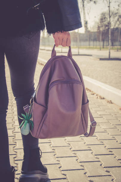 istock Girl with a backpack in hand walks in the park 1210829241