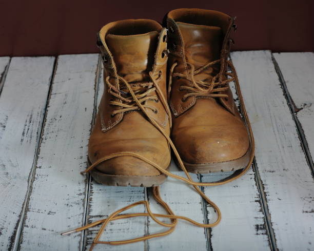 istock Work boots, with white architect's helmet and metric tape 1210830330