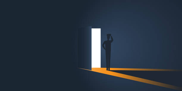 istock Uncertain Man in a Dark Room with Light Through an Open Door 1210831079