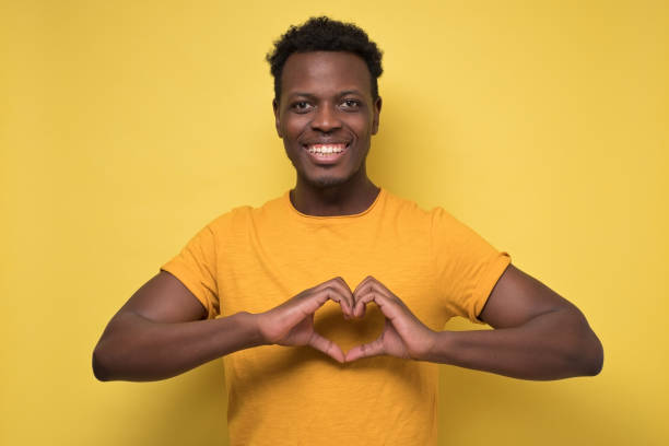 istock guy cheerfully and making heart gesture over chest, expressing his feelings 1210831168
