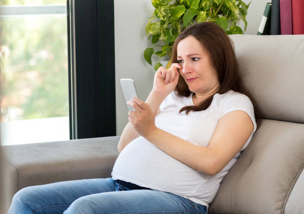 istock Sad teen crying after read phone message at home 1210832392