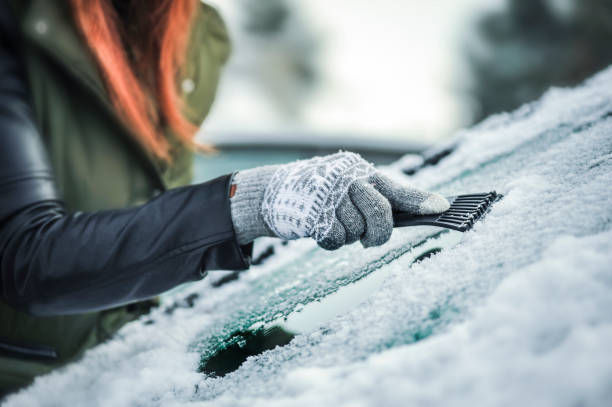 車の窓から雪を掃除。フロントガラスから雪を取り除く - snow car window ice scraper ストックフォトと画像