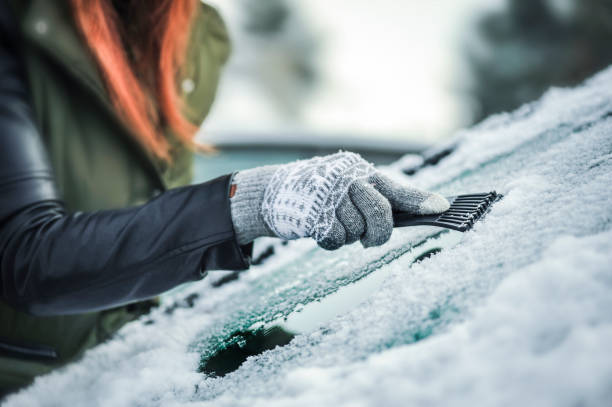 czyszczenie śniegu z okna samochodu. usuwanie śniegu z przedniej szyby - snow car window ice scraper zdjęcia i obrazy z banku zdjęć