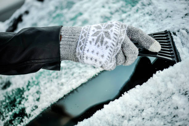 車の窓から雪を掃除。フロントガラスから雪を取り除く - snow car window ice scraper ストックフォトと画像