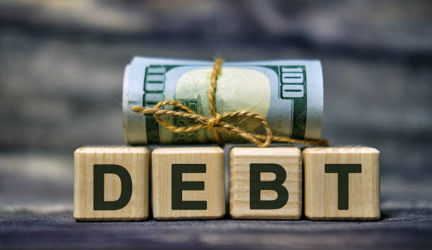 istock DEBT word concept on cubes with a Banknote 1210834884