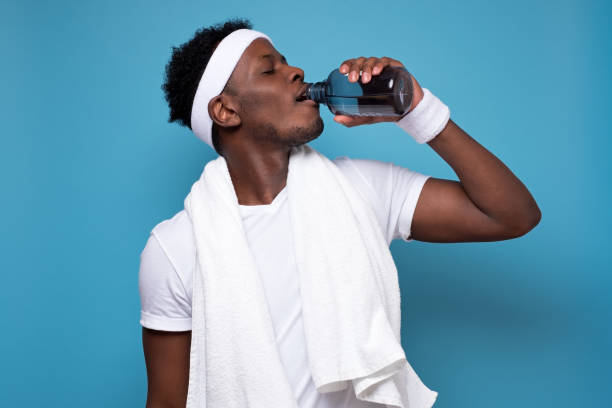 istock Young african sportsman drinking water after training. 1210835400