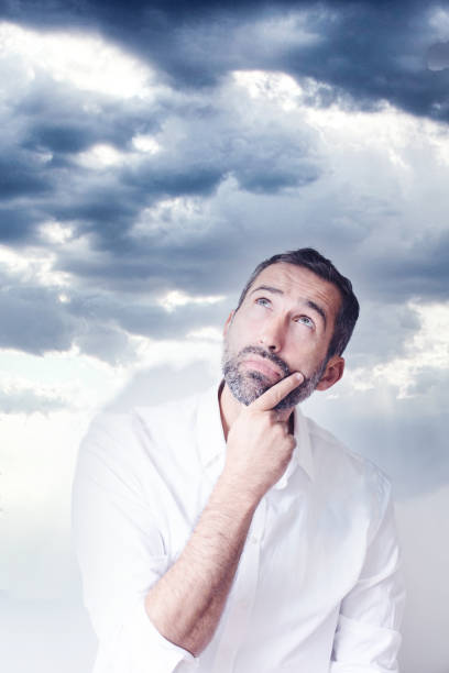 istock Portrait of a man looking thoughtfully up into the blue sky 1210837334