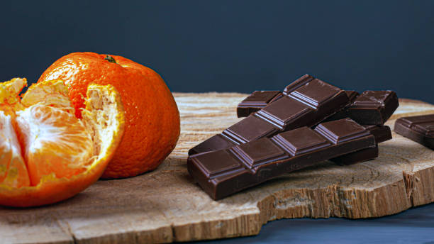 istock chocolate and tangerines on wood board and dark background 1210837808