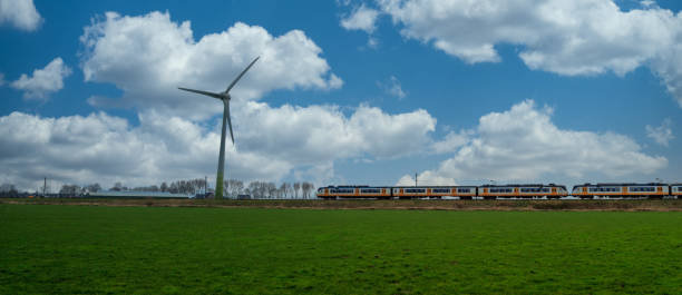 istock Passenger train and wind turbine panorama 1210839059