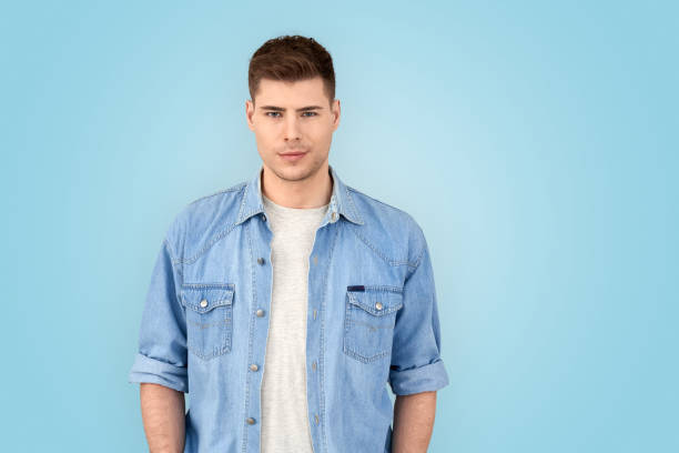 istock Freestyle. Young man in jean jacket standing isolated on gray siling confident 1210842909