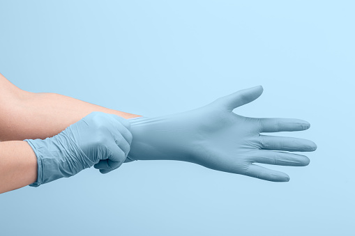 Manos de la doctora que se ponen guantes quirúrgicos esterilizados blancos photo