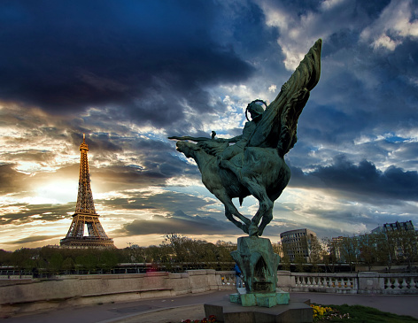 A beautiful Picture of Paris, including the Eiffel Tower, with the famous statue of Jeanne of Arch in the foreground at Bir Hakeim bridge
