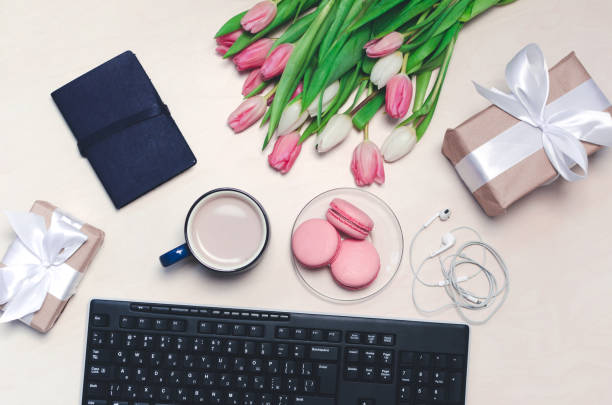 tasse de café, fleurs de tulipe de printemps et macarons roses et clavier et écouteurs sur la vue de dessus de table pastel. - fresh coffee audio photos et images de collection