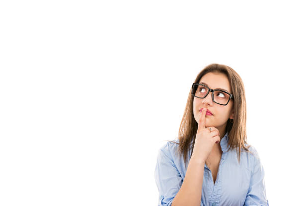 Young thinking woman in glasses touching lips and looking up contemplating on idea isolated on white background