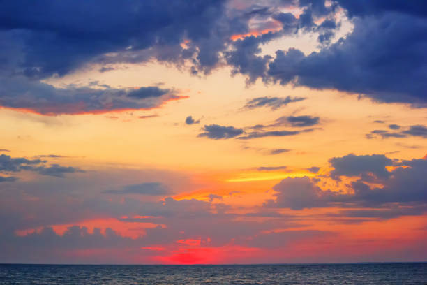 istock Beautiful red summer sunset (sunrise) with floating clouds over the sea 1210849229