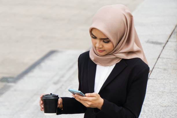 istock Beautiful asian muslim woman multitasking with her mobile device 1210855435