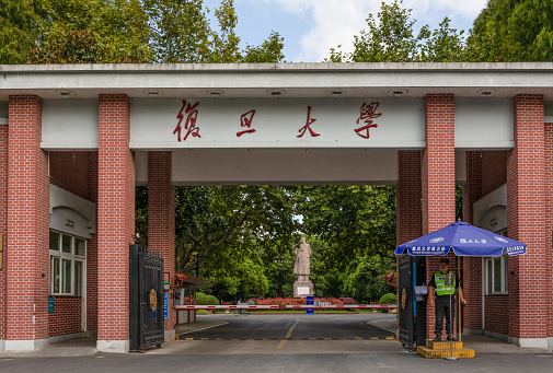 Shanghai, China - September 19, 2019:  Main Gate or Entrance of Fudan University on Handan Campus, Yangpu, Shanghai, China. Statue of Mao Zedong is behind the gate in the middle.