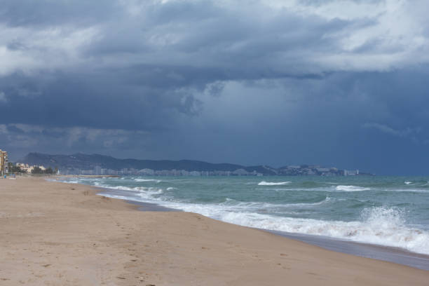 istock Landscape blue storm clouds over sandy beach with city skyline 1210861664
