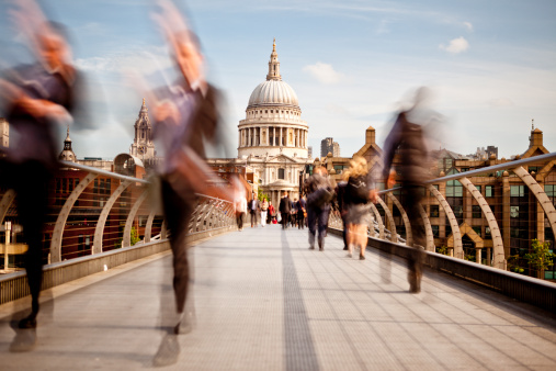 People walking along Millennium Bridge with St Pauls Cathedral in the background. Slow shutter gives motion blur to the passers by.