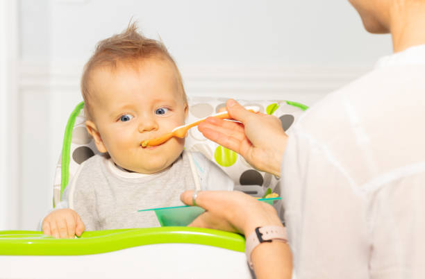 istock Mother feet toddler boy breakfast from spoon 1210862799