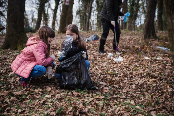 istock Girls helping adults in collecting litter 1210863821