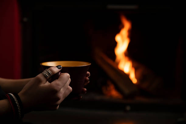 istock Girl drinking tea in front of the fireplace 1210868943