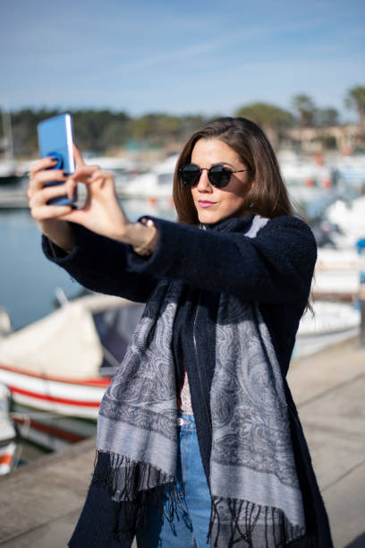 istock Pretty woman taking selfies in marina 1210868973