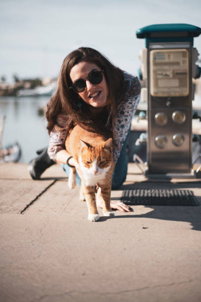 istock A girl with a cat by the harbor 1210868984