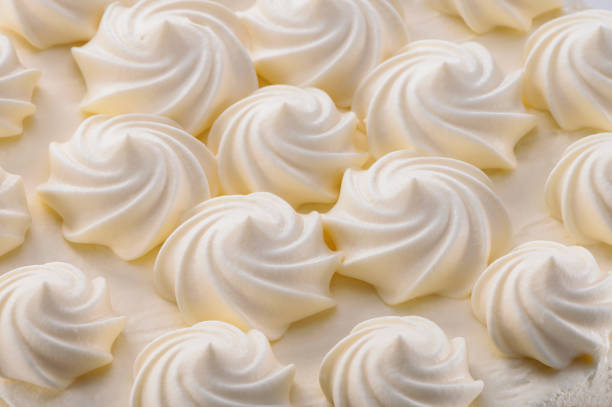 istock cream curls decoration on cake top close-up background 1210879394