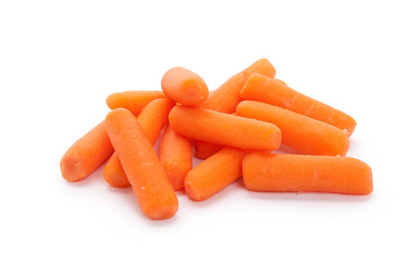 A pile of baby carrots on a white background stock photo