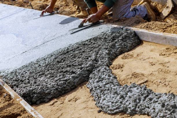 istock Construction workers laying concrete mixer with concrete mixer on sidewalk 1210882537
