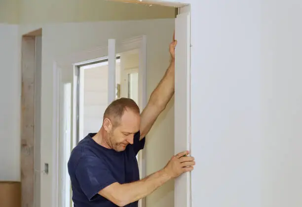 Carpenter to moldings on doors, framing trim, with the doorway