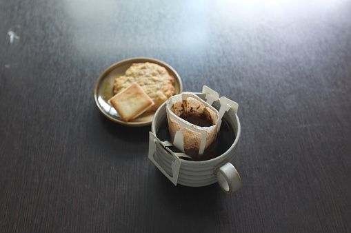 Instant freshly brewed cup of coffee,Drip bag fresh coffee served with cream crackers .  copy space for text insertion