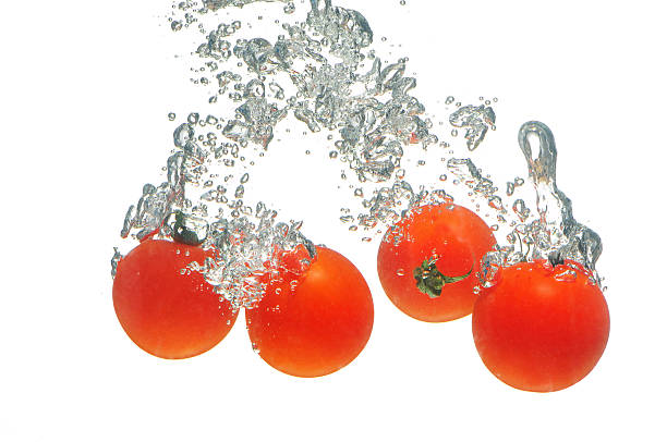 Tomatoes falling in water stock photo